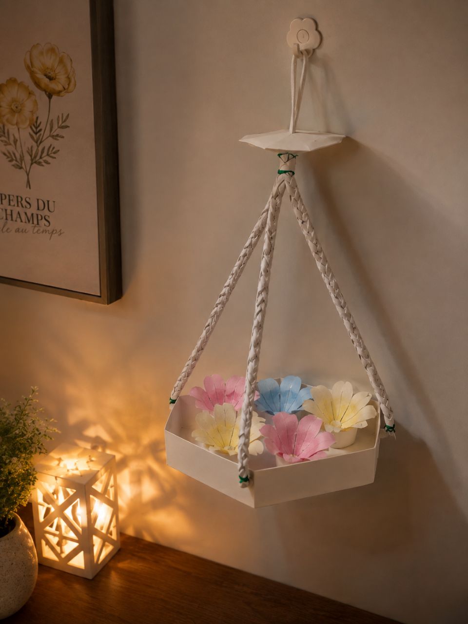 Hanging white paper basket with pastel paper flowers beside a glowing paper lantern